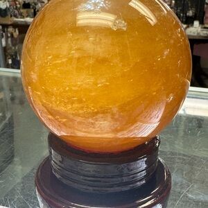 High Quality Honey Calcite Sphere with a wooden stand.